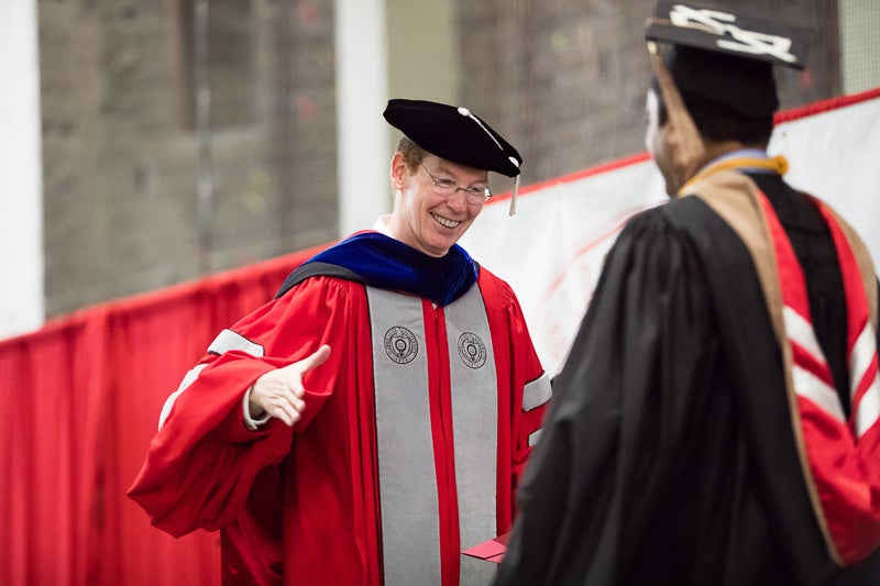 Photo of Mark Nelson shaking a graduate
