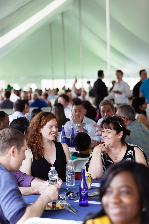 Photo of families sitting at table under a tent