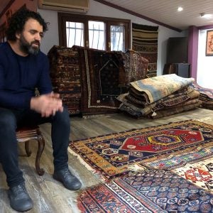 A man sitting in a rug shop