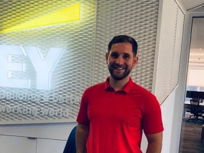 A picture of Benjamin Goulet standing next to the EY logo