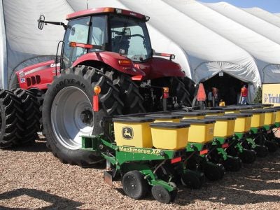 Photo of a red farm tractor with John Deere implements