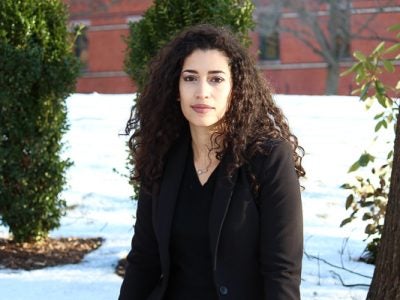 Headshot of Fayrouz sitting outside of Sage Hall in the snow