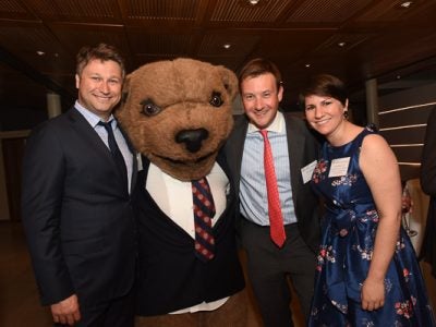 Photo of Touchdown the Bear with three people