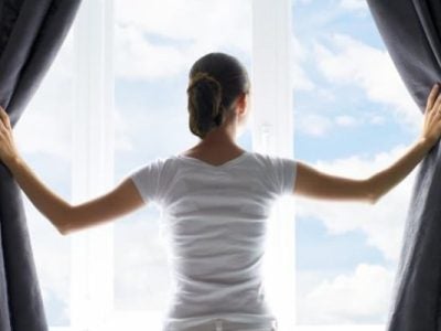 Person opening the curtains to reveal a window