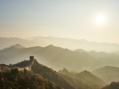 the Great Wall of China surrounded by hills on a foggy morning