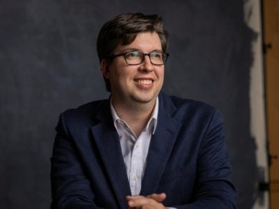 Headshot of a seated man wearing a suit jacket.