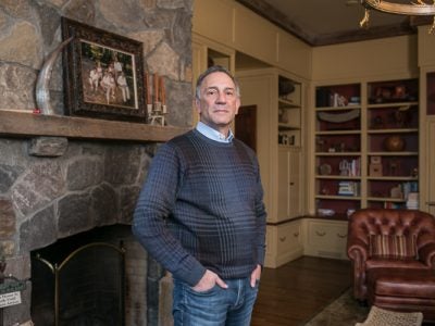 Photo of Gary Mendell standing in front of a fireplace and mantel