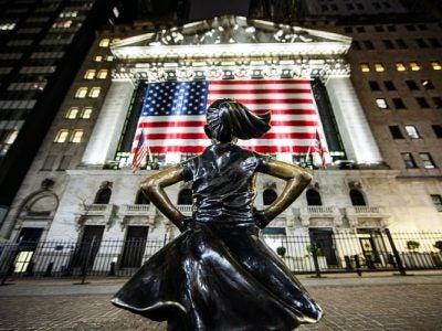a statue of a girl stands in defiance on WallStreet