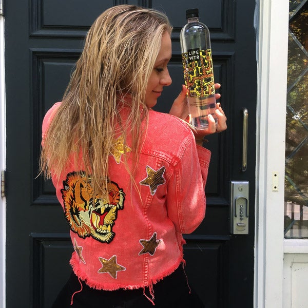 Photo of Grace holding a LifeWtr bottle with matching jacket
