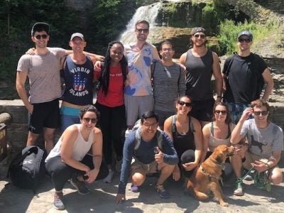 Students stand in front of a waterfall