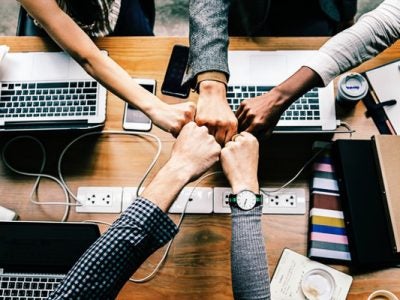 Fist bumping across laptops