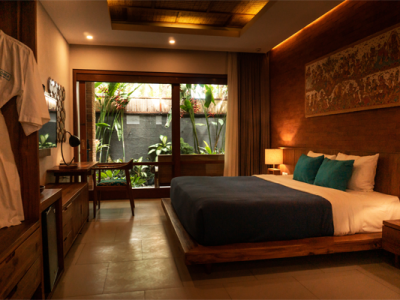 hotel room with bed and porch with tropical plants