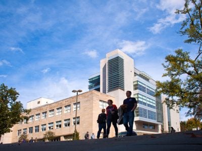 Photo of students walking in front of Statler Hall on a sunny day