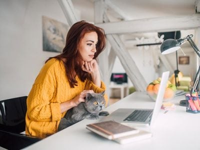 Woman working from home and petting an animal