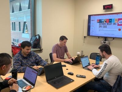 Students working on computers in a breakout room