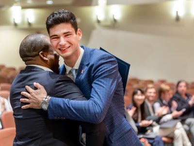Lucas Suero ’26 hugs fellow competitor Christopher Browne, MPS '23 after winning the 13th annual hospitality business plan competition.