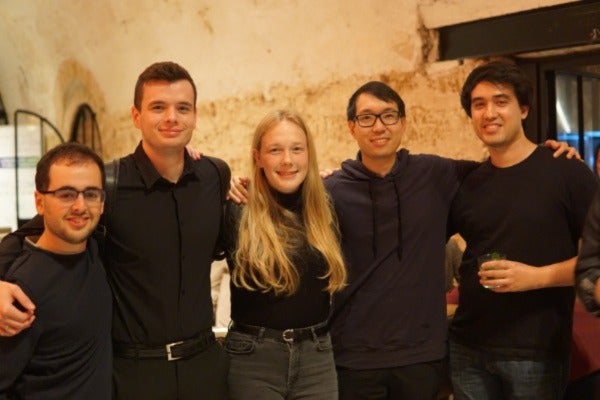 4 male and 1 female student standing with arms around each other