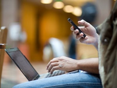 Photo of a person on a laptop and phone