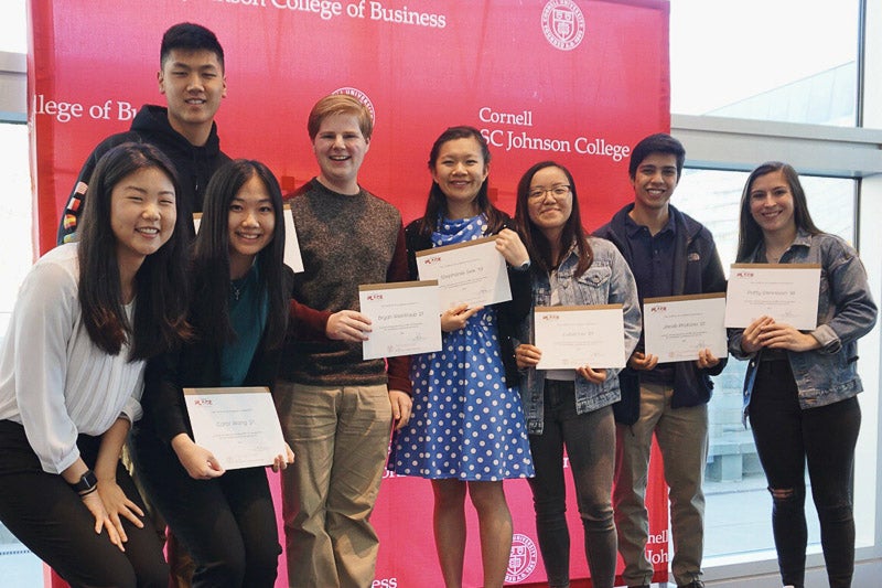 Photo of Jaimie with students holding certificates