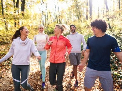 People jogging on a path in the wooods.
