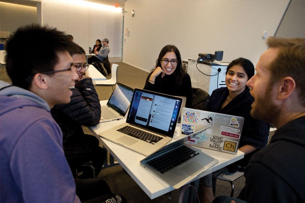Students collaborate over laptops in a small classroom at Cornell Tech campus in NYC