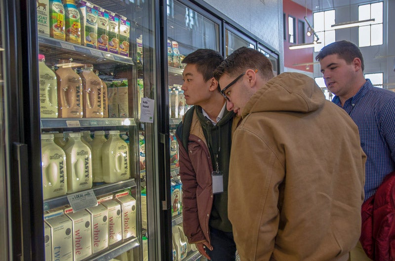 Students looking at coolers of milk
