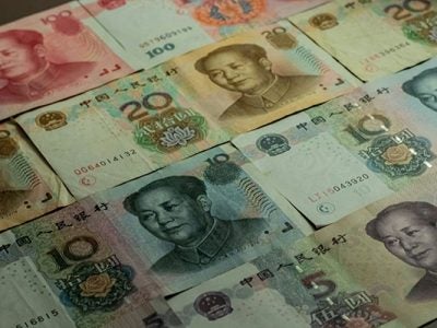 A tabletop covered with lots of different Chinese Renminbi bills.