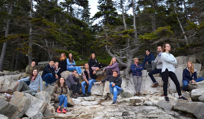 Interns in a group photo on boulders