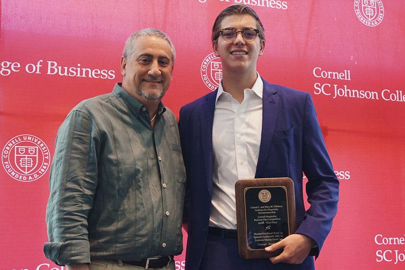 Photo of Neil and Hunter holding a plaque