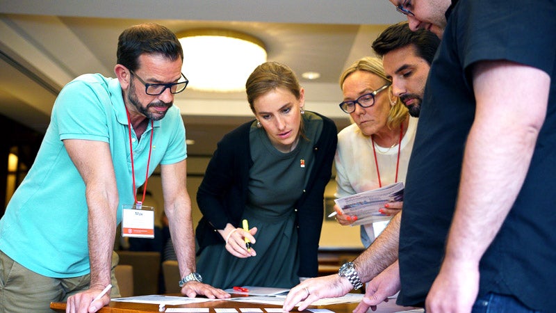 Photo of people working on an activity and taking notes at a table