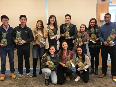 Photo of a group of ambassadors holding pineapples