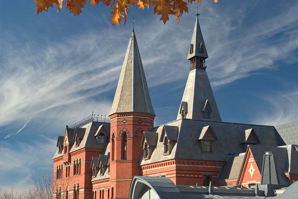 Exterior of Sage Hall, a gothic-inspired stone and steel building on the Cornell University campus in Ithaca, New York, across a backdrop of cirrus clouds on a sunny autumn day