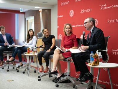 Five panel participants at the front of the room