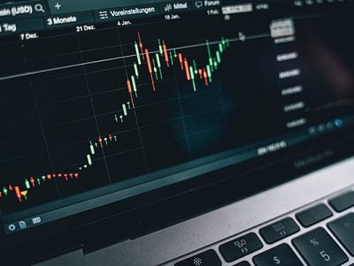 laptop computer screen graph showing daily fluctuations in Bitcoin value.