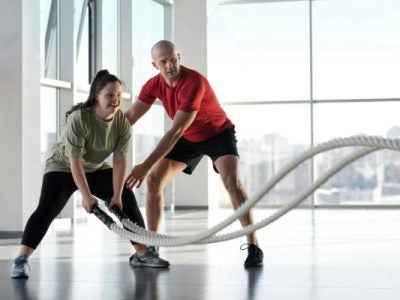 Woman holding ropes beside a trainer