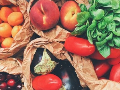 Brown bags filled with fresh fruits and vegetables