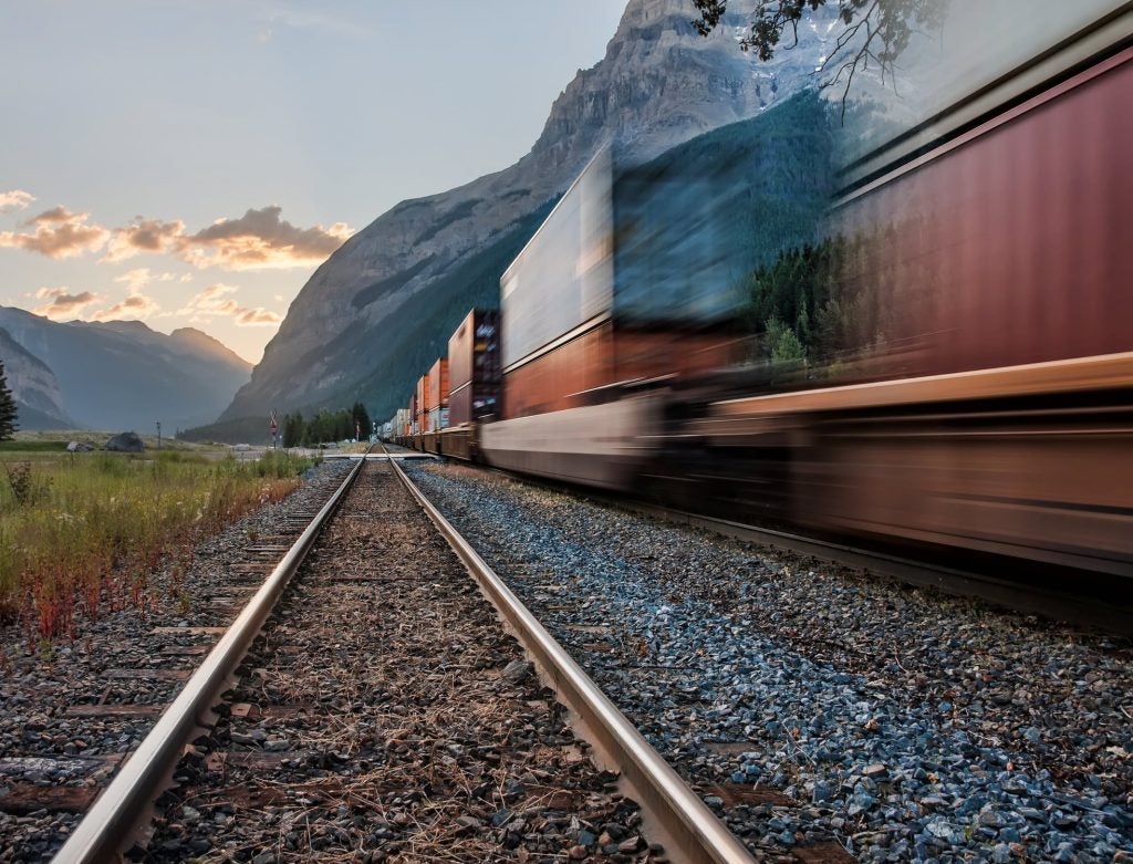 A train speeding past near a mountain range