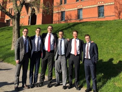 Photo of Daniel and his teammates standing in the grass outside Sage Hall