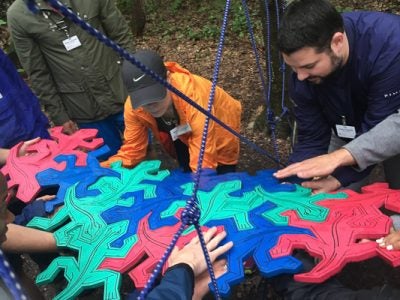 Photo of people working on a large puzzle outdoors