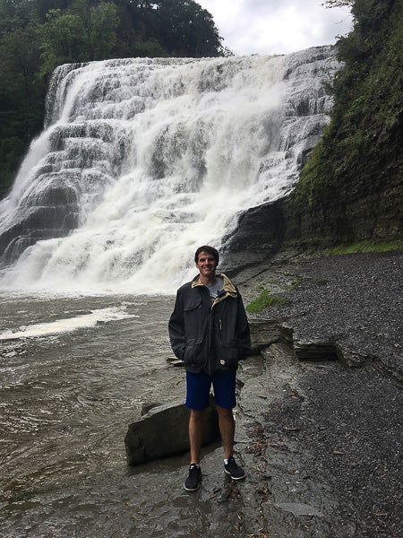Photo of Matt standing in front of a waterfall