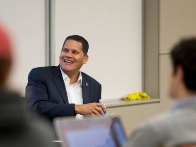Reggie sits at the front of a classroom