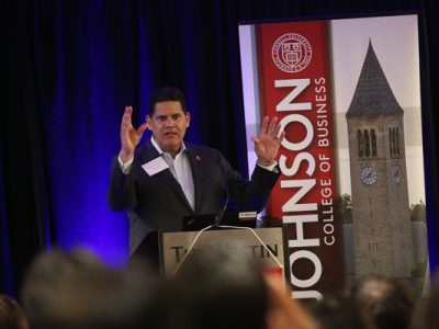 Reggie standing in front of a Cornell SC Johnson College of Business sign