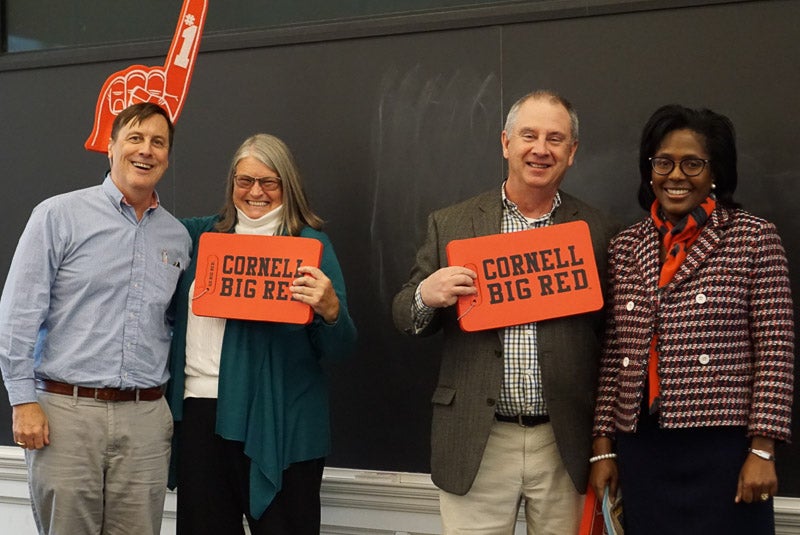 Photo of faculty holding Cornell Big Red signs