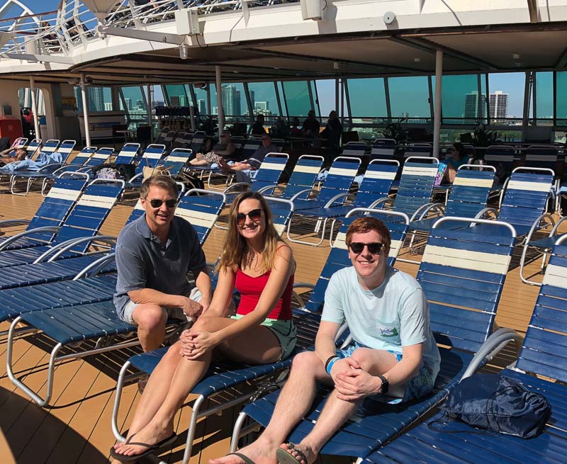 Photo of three people sitting in beach lounge chairs