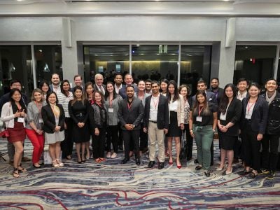 A large group poses for a photo in a reception space