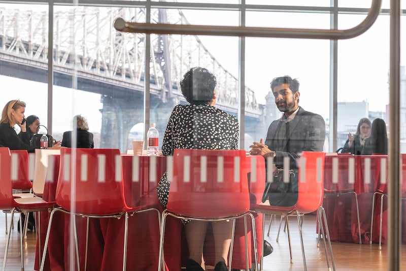 A student and mentor seated at a table in a Cornell Tech meeting space