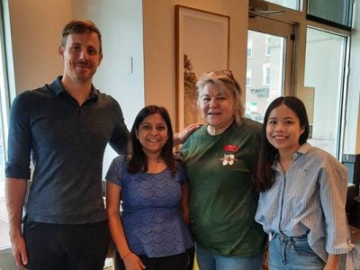 A man and three women standing next to each other and smiling.