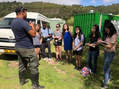 Photo of Basil Williams addressing the group of students in the field