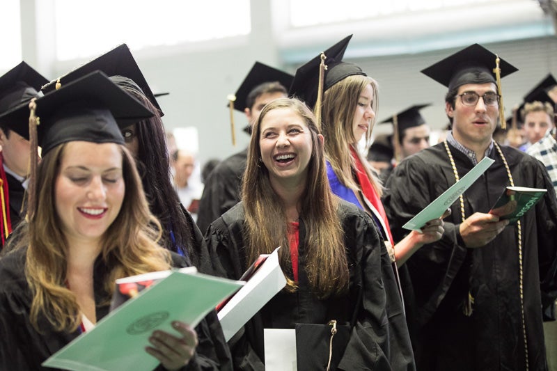 Photo of a smiling graduate standing in line