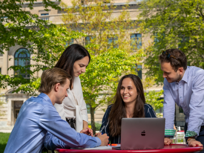 group of students having a discussion over a laptop